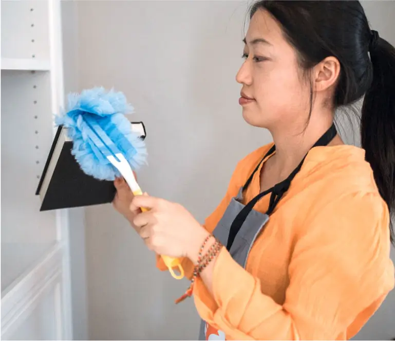 A woman holding a blue mop and a blue duster