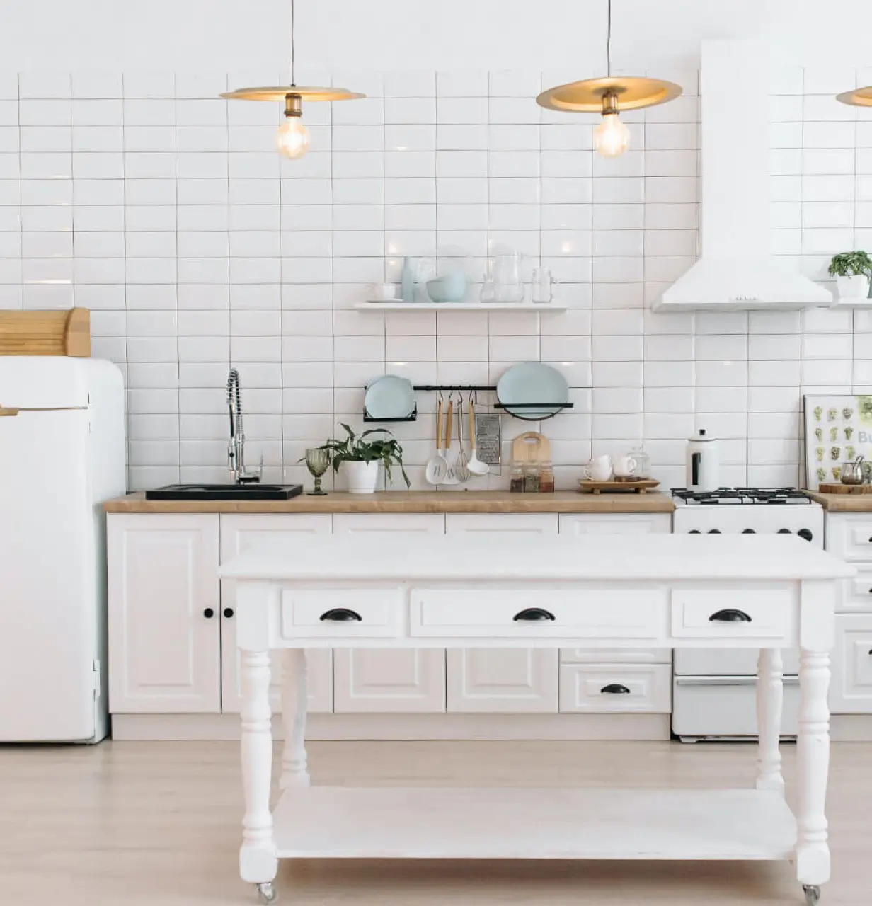 A white kitchen with a table and a refrigerator